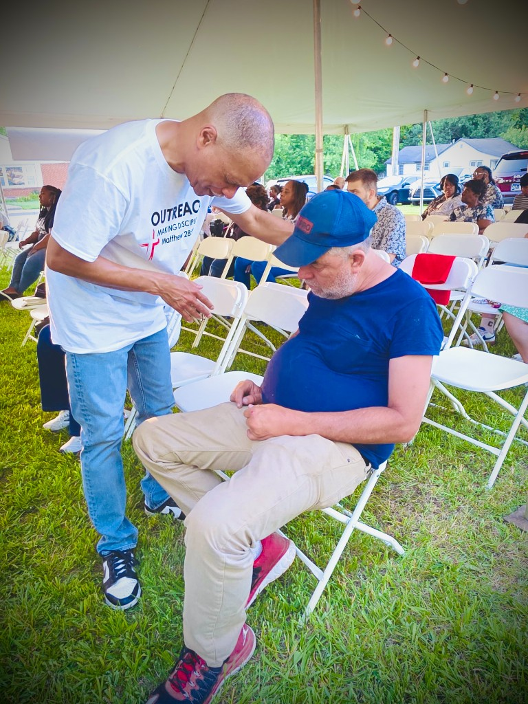 Outreach team member praying with a guest