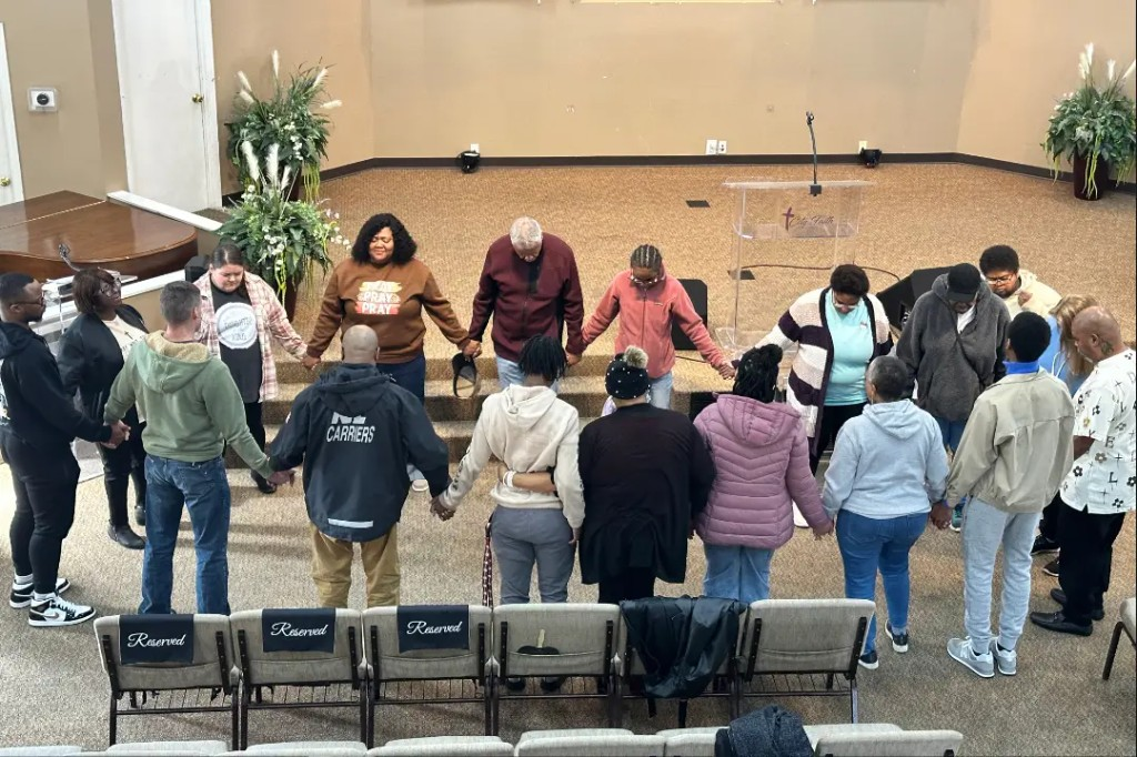 Congregation praying together in a circle at City of Faith